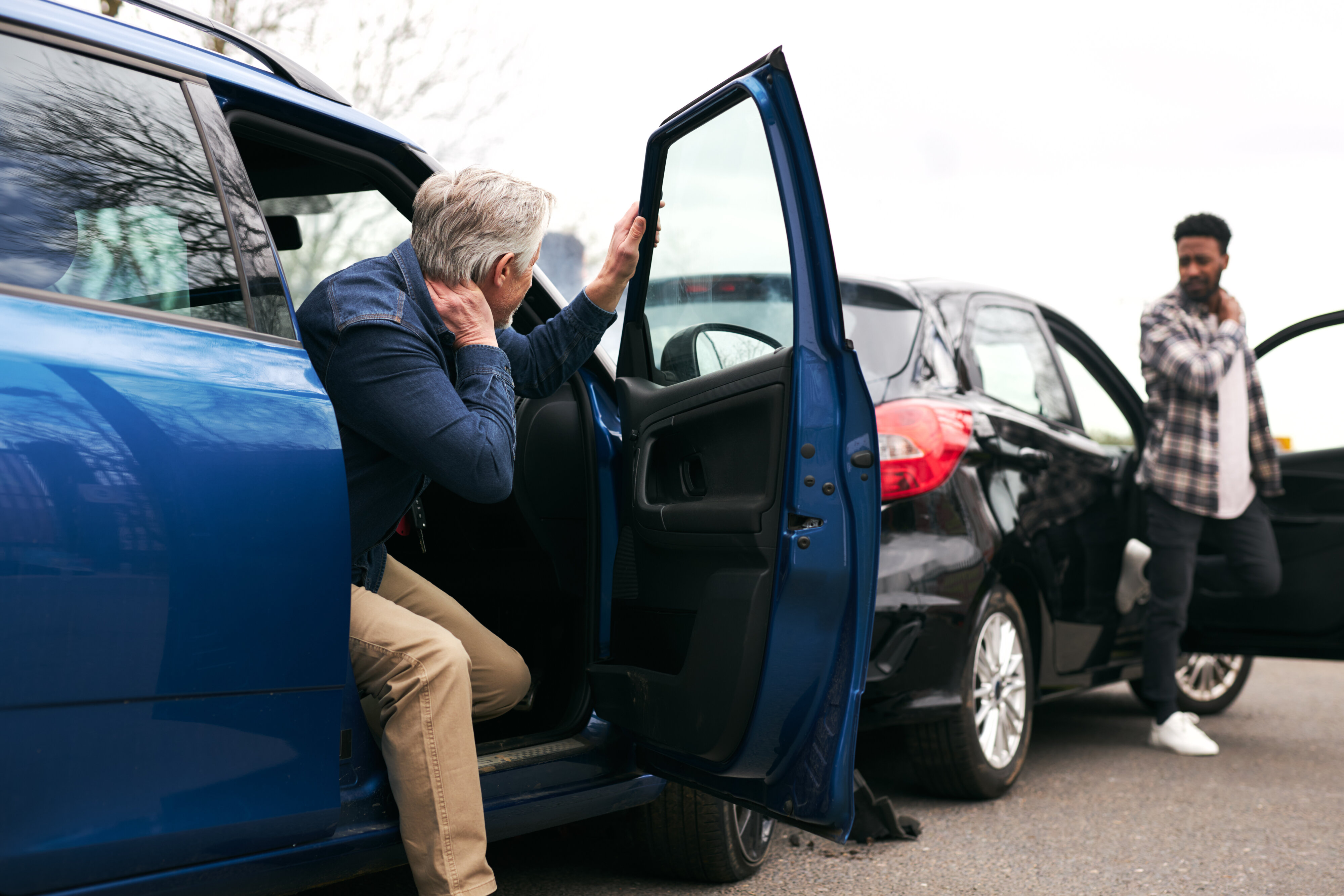 Two males getting out of their car after a car accident