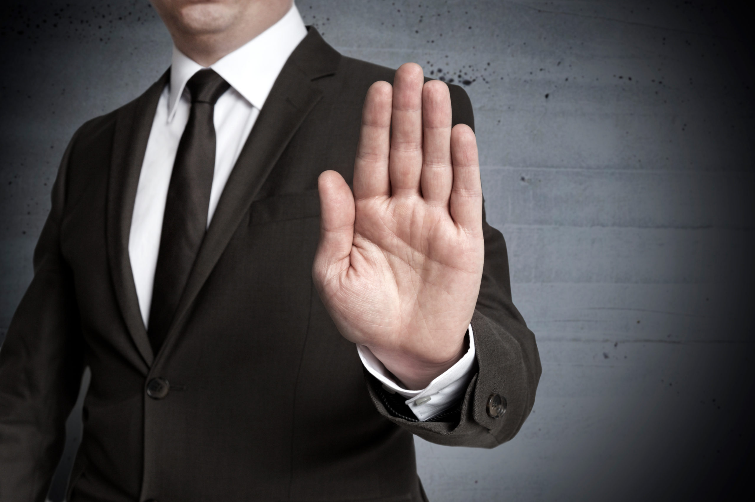 Man in a suit holding his hand up