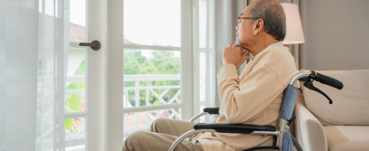 older gentleman sitting in a wheel chair staring out the window
