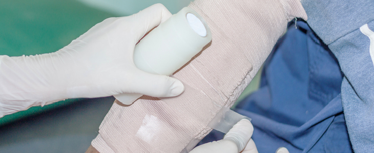 Doctor bandaging a man after suffering dog bites