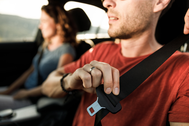 Young driver using his seatbelt when driving