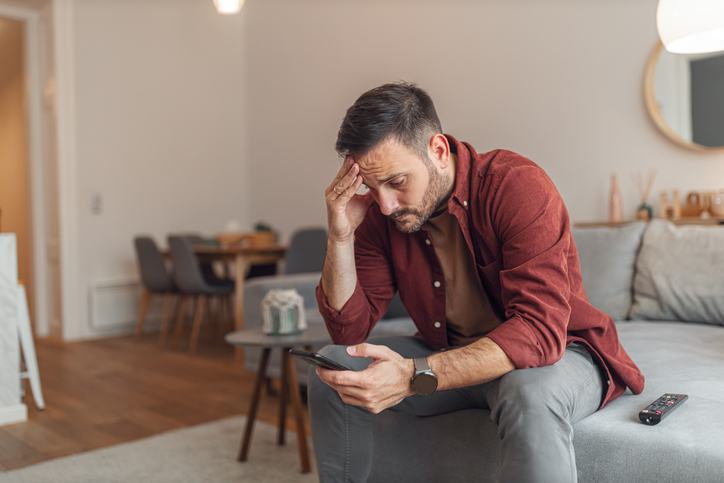 Stressed man sitting on a couch