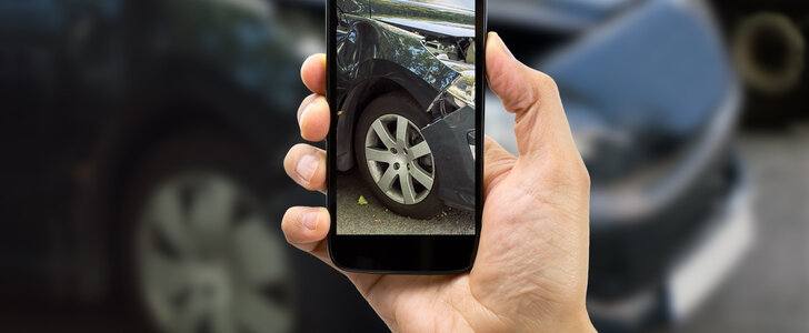 Man photographing his car after an accident.