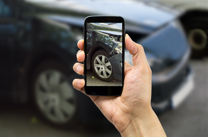 Man photographing his car after an accident.