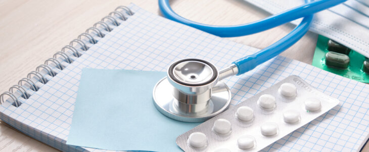 medicines, pills, medical stethoscope and notepad for notes on the table, disease diagnosis concept