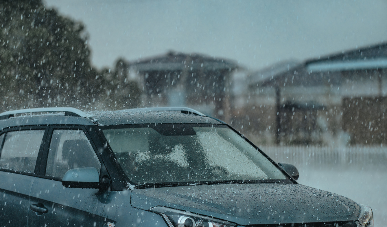 Heavy rain with hail on a car.